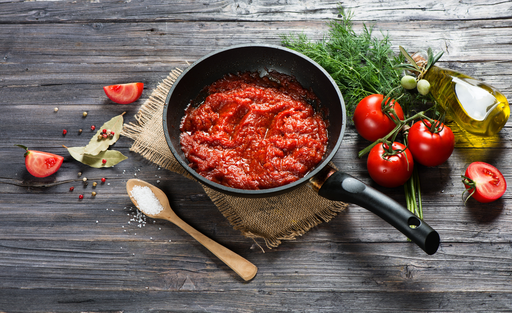 Tomato sauce in a pan and ingredients